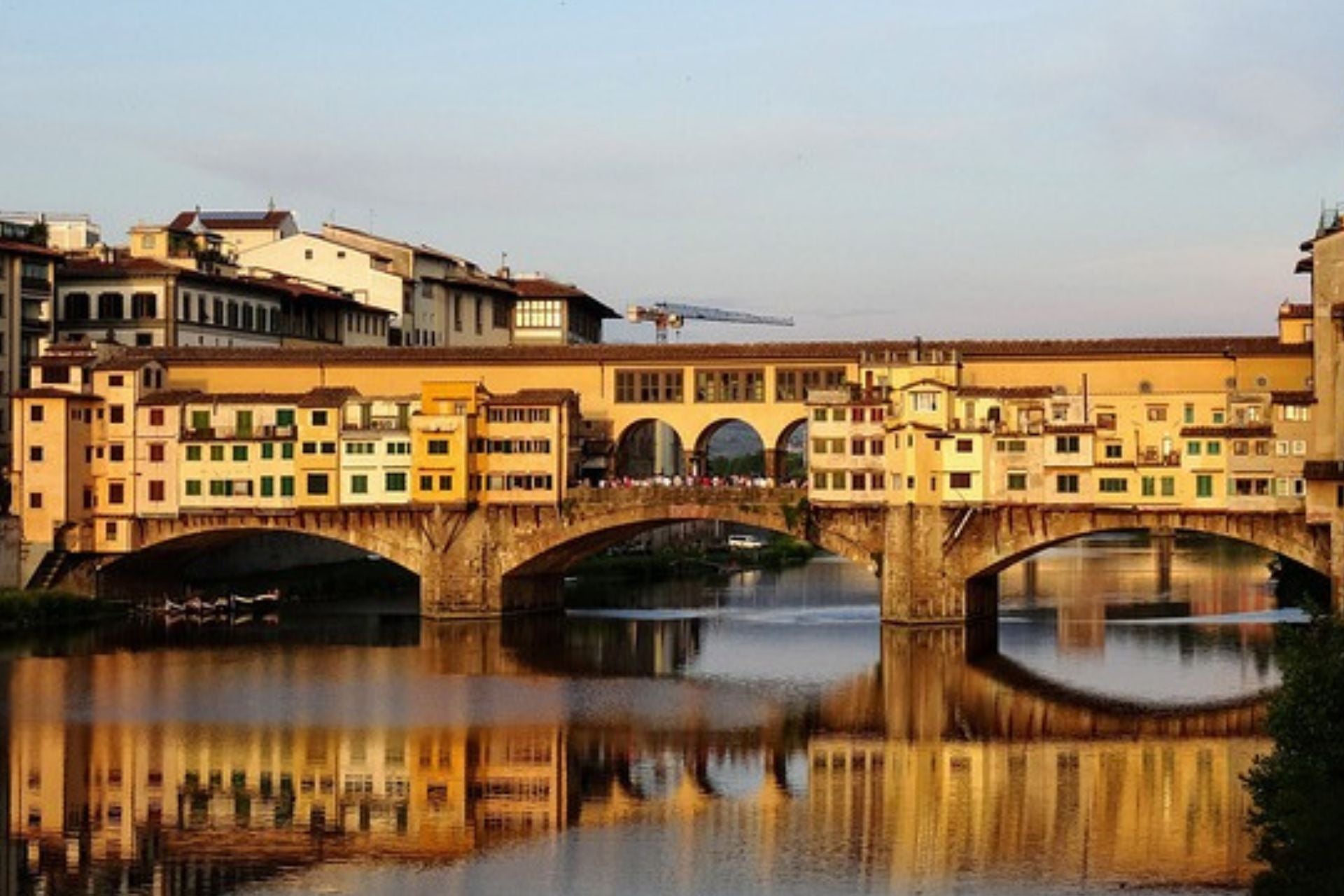 Ponte Vecchio brug met huizen en winkels over de rivier de Arno in Florence Italië