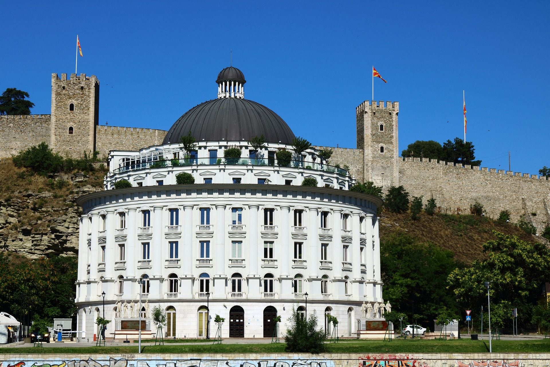 Wit rond gebouw van het waterbedrijf van Skopje met op de achtergrond Fort Kale