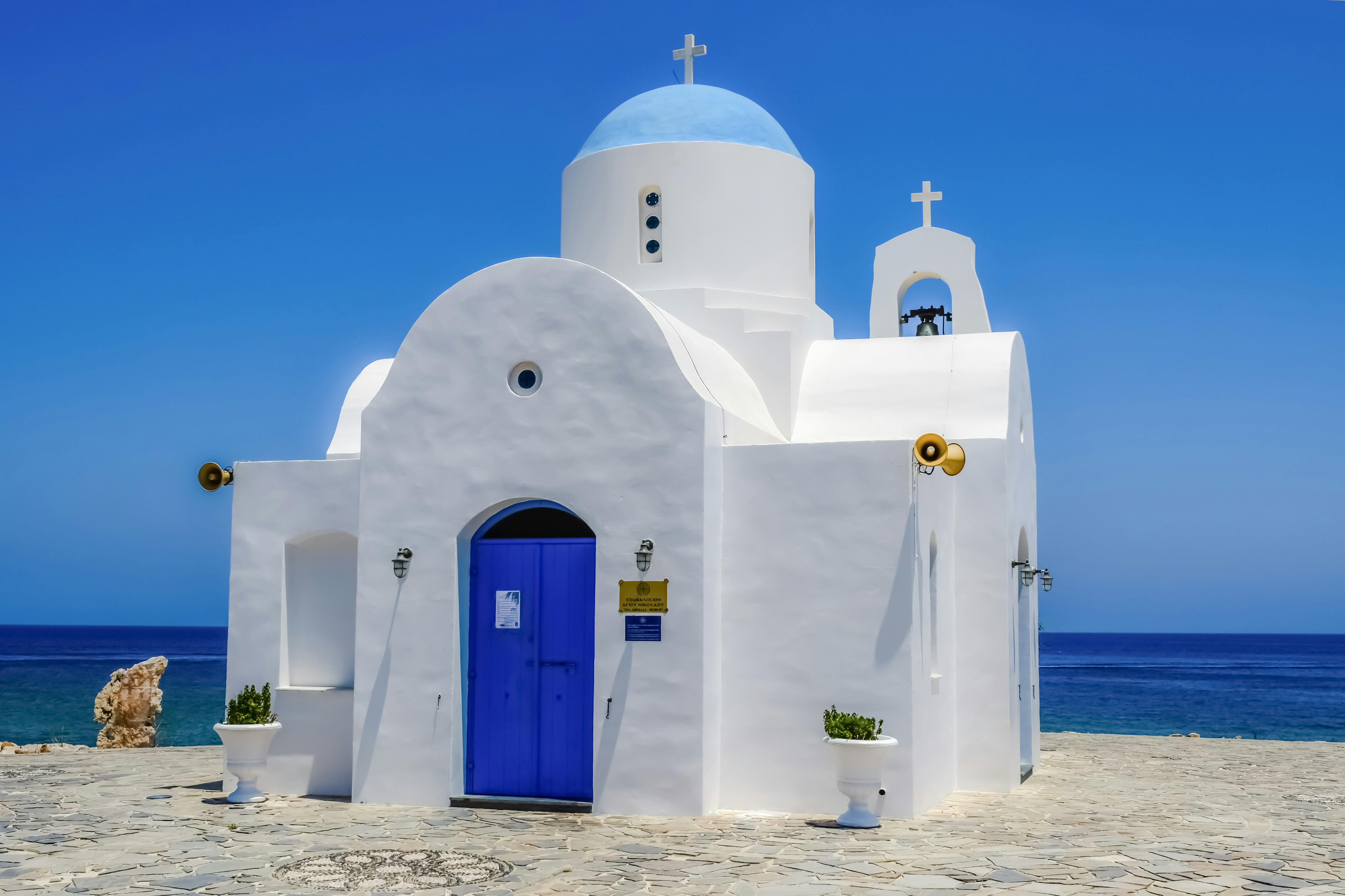 Witte kerk blauwe deur aan zee Cyprus