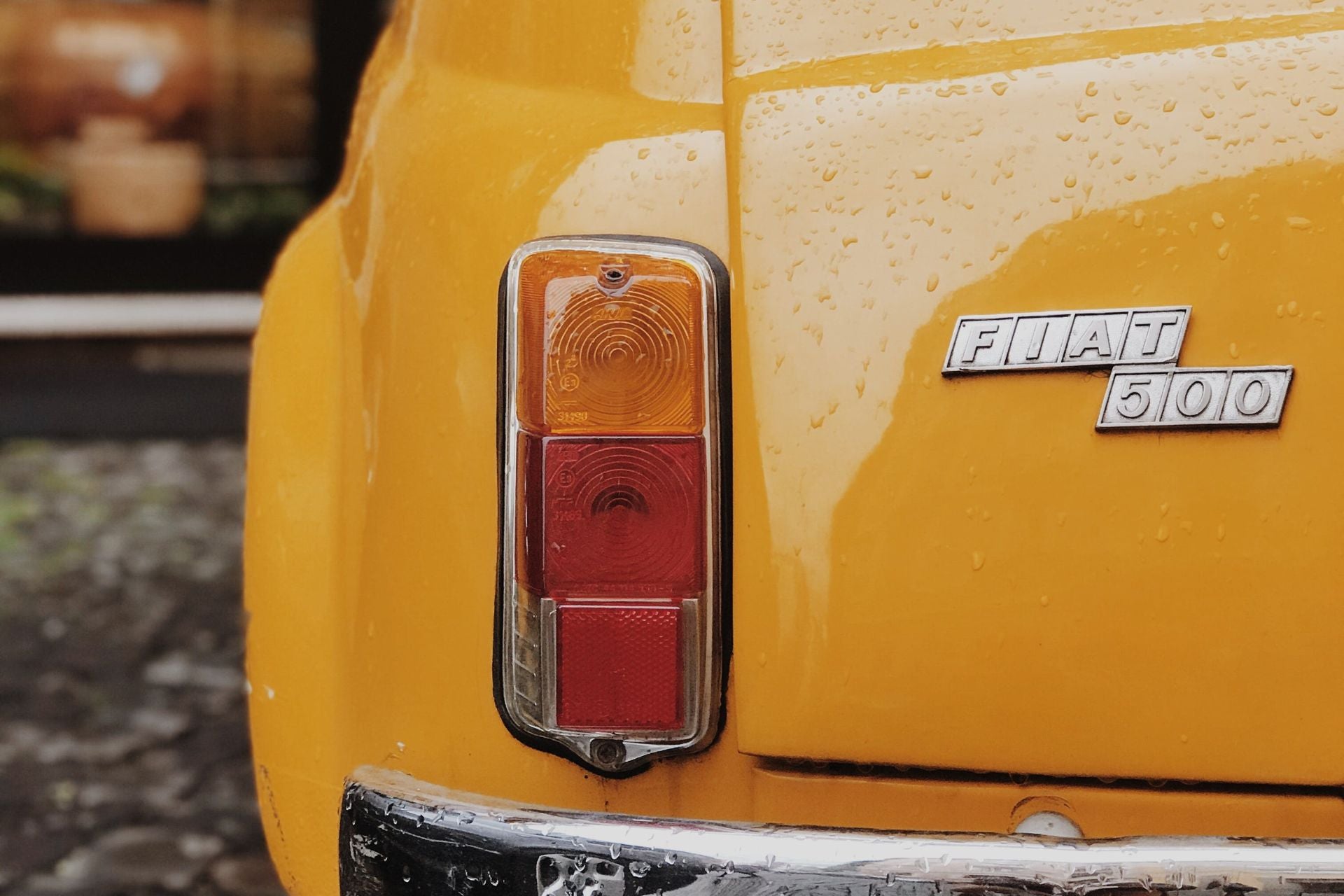 Detail met achterlicht van een klassieke gele Fiat 500 