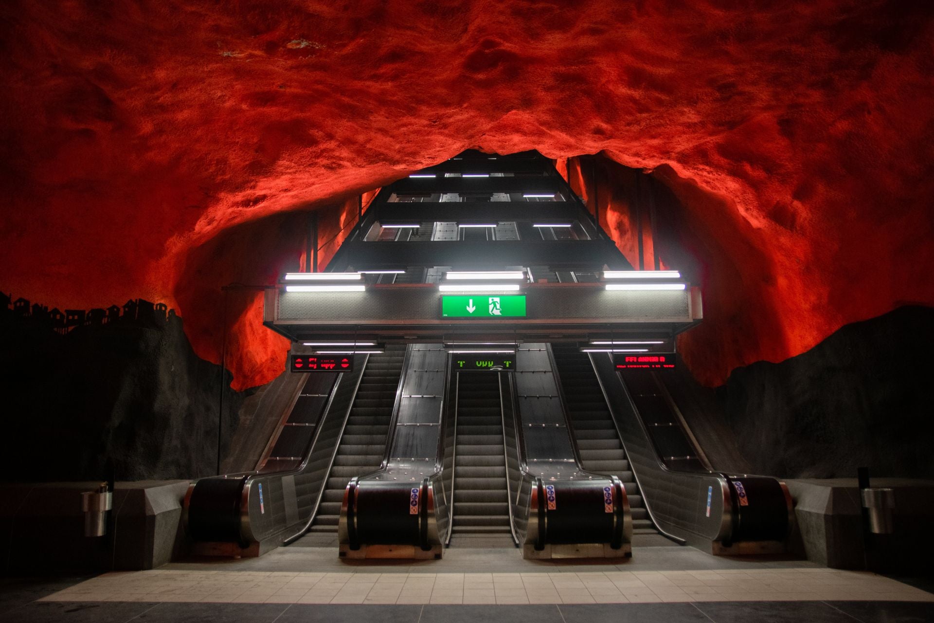 Roltrappen in de metro van Stockholm met vuurrood rotsplafond