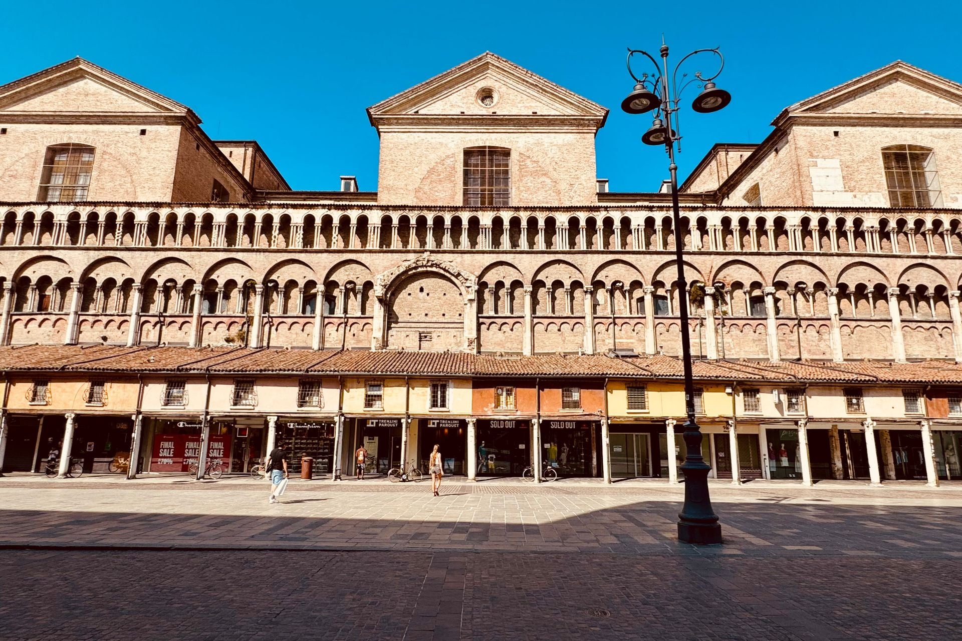 Loggia met oude winkeltjes aan de zijkant van de Duomo van Ferrara uniek