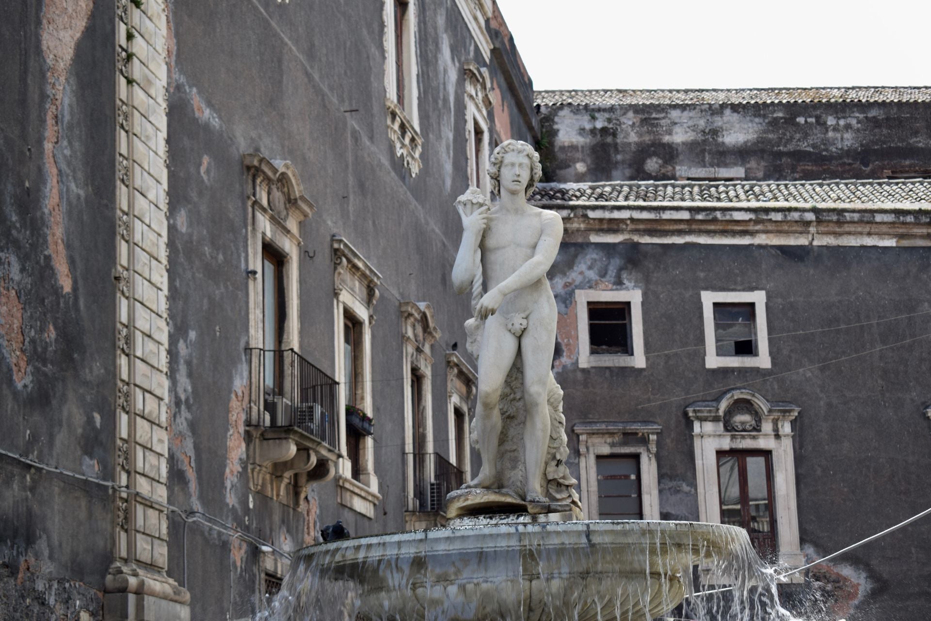 Stenen beeld van den naakte man op Fontana dell'Amenano in Catania
