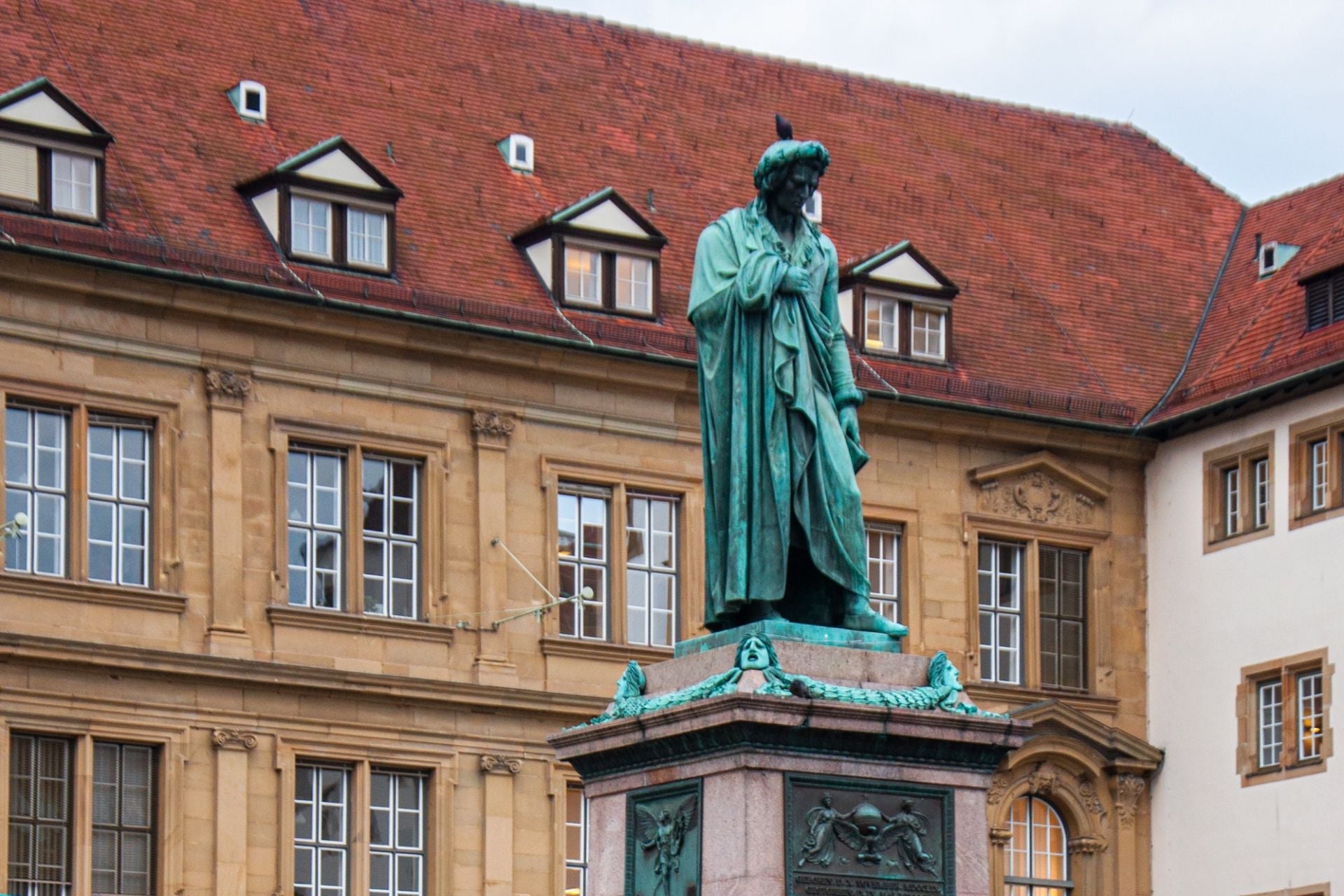 Beeld van Schiller in Stuttgart met oud gebouw op de achtergrond